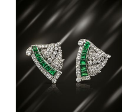 A pair of Art Deco emerald and diamond-set clip brooches, each clip set with a line of graduated tapered baguette-shaped emer