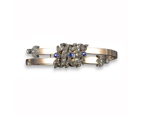 A Victorian sapphire and diamond bangle, set with a central panel of sapphire and diamond laurels in silver and gold, with ro