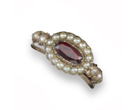 A George III garnet and seed pearl cluster ring, centred with an oval-shaped garnet set within a surround of seed pearls in c