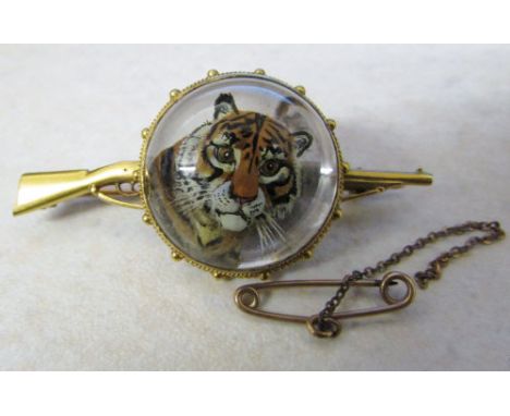 Tested as 9ct and 15ct gold reverse crystal intaglio brooch of a tiger with gun form bar (safety chain needs reattaching) L 5