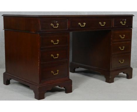 A Georgian style mahogany three section pedestal desk with an arrangement of nine drawers on bracket feet. H.76 W.135 D.69cm 