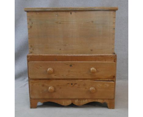 A 19th century pine mule chest with lidded coffer section fitted with candle slide above two drawers on shaped bracket feet. 