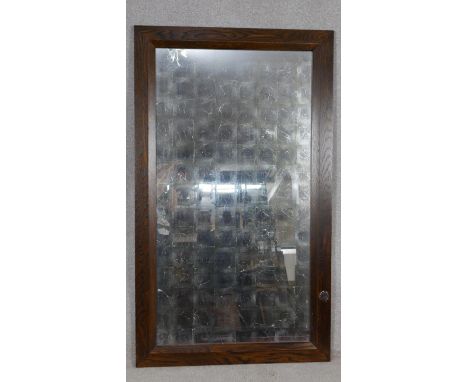A large oak framed wall mirror with opaque antique style silvered plate. H.148 W.87cm 