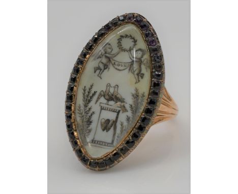 A Georgian red metal mourning ring, the navette-shaped ivory panel painted en grisaille to depict a plinth with two doves and