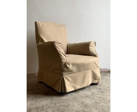 An Edwardian easy chair, with a beige fitted cover, raised on shaped stained supports with ceramic castors, H96cm, W76cm, D85