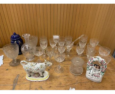 A quantity of glass including sherry glasses, also a decanter of bolster form, a milk jug in the form of a cow, ceramic figur