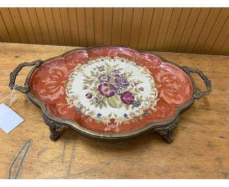 A ceramic tray with floral and scrolling vine decoration in a brass mount with two handles to sides and feet base of tray mar