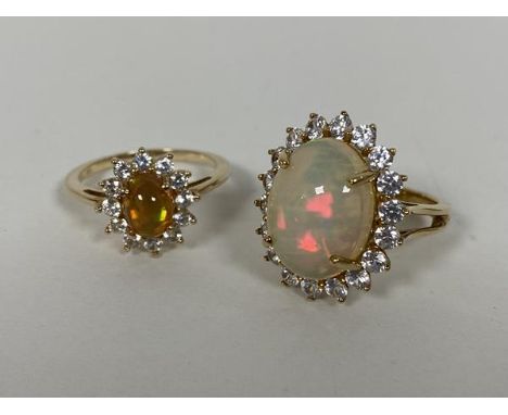 Two 9ct gold cluster rings, each with an opal cabouchon surrounded by clear stones (P) (combined: 9g)