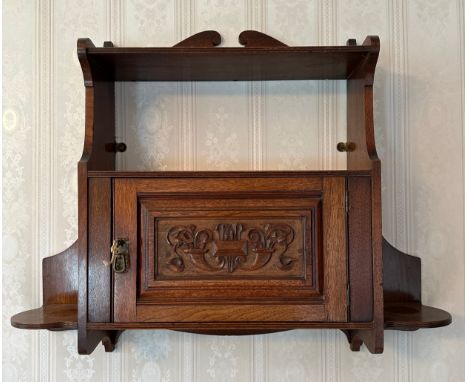 A mahogany wall hanging cabinet with single door cand shelf, carved decoration to front of door. 58 h x 68cm approx. 