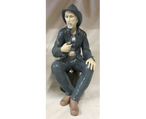 A large Nao figure modelled as a fisherman seated smoking a pipe, 39cm h. 