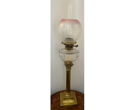 A 19thC oil lamp with brass Corinthian column, clear glass reservoir and etched pink and clear glass shade. 81cm h to top of 