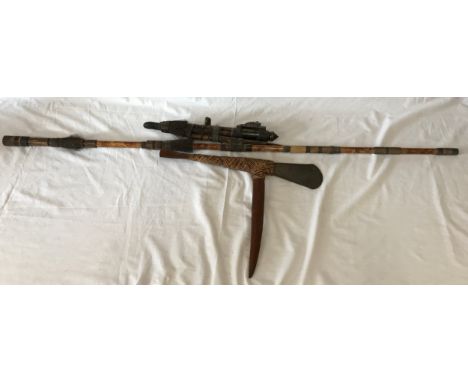 A decorative bamboo blow-gun along with a Papua New Guinea tribal axe. 
