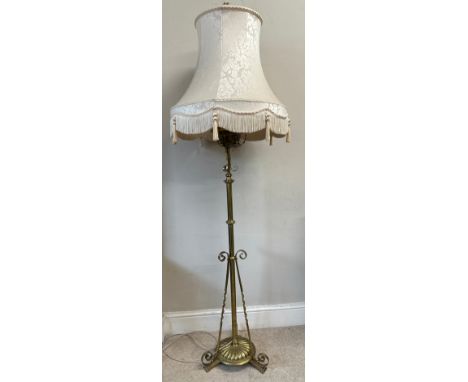 A decorative scrolled brass standard lamp with shade converted from an oil lamp. 151cm h without fitting. 