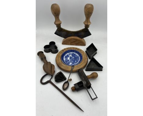 Kitchenalia to include Queens cake tins, wooden lemon squeezer, unusual nutmeg grater, hallmarked silver spoon, double handle