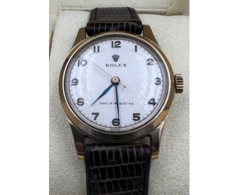 A boxed 9ct gold gentleman's precision Rolex wristwatch on brown leather strap with blue and gold hands. 30mm case. Inner cas