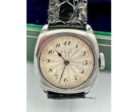 A ladies stainless steel Rolex wristwatch on black leather strap and square case. In green Rolex box. Case 28mm.Winds but doe