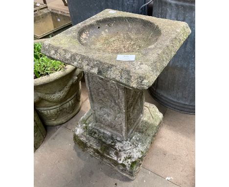 A concrete garden bird bath 