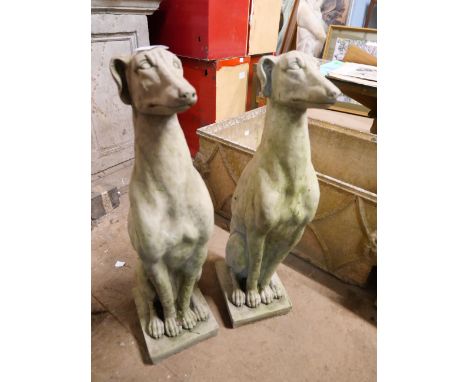 A pair of concrete garden figures of seated greyhounds 