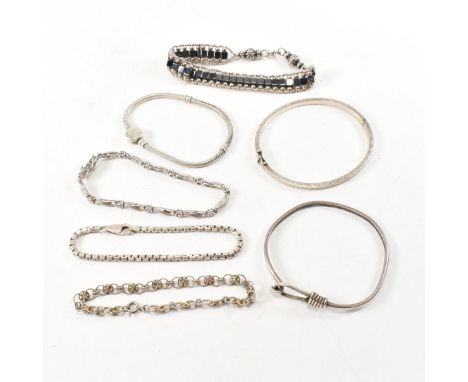 A collection of silver bracelets. The seven bracelets to include a silver hook and eye bangle, marked 925. An 835 silver engr