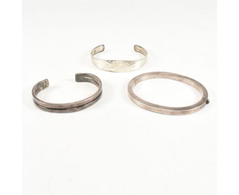 Three silver bracelets. The bracelets to include a silver hinged bangle, marked 925. A hallmarked hammered silver bangle, ins