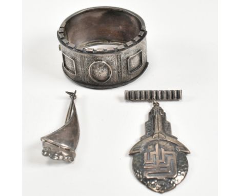 A silver hinged bangle and brooch pins. The silver jewellery to include a silver hinged bangle with a triple bright cut engra