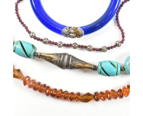 A Chinese glass bangle and beaded necklaces. The lot to include a Chinese blue glass bangle with sterling silver decorative b