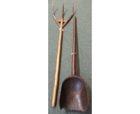 A wooden grain scoop (length 140cm) and a wooden pitch fork (length 163cm)