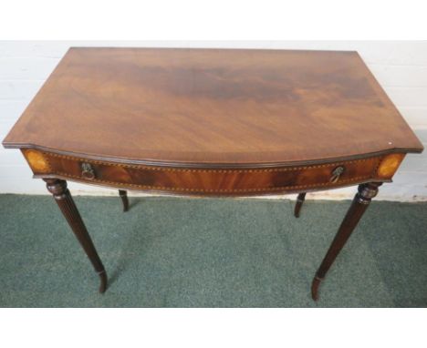 Banded mahogany veneer bow fronted single drawer side table, the drawer with ebony and boxwood feather stringing and lion's m