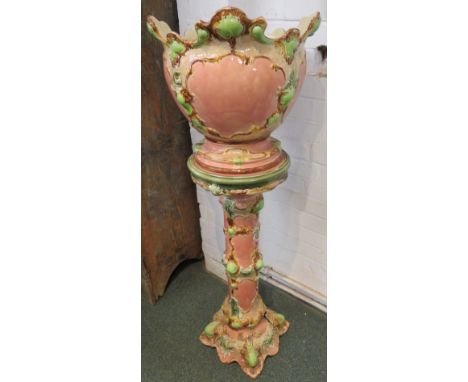 Victorian majolica jardiniere on stand, pink ground with green and brown oak foliage, requires restoration, the base of the p