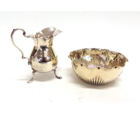 A SILVER CREAM JUG by Charles Edwards, London 1918, of Georgian helmet shape on three supports, 10.5cm high, 103g (3.3 troy o