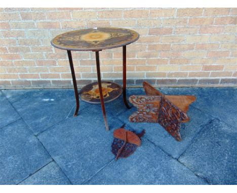 AN OVAL INLAID OCCASIONAL TABLE with under shelf, 63cm wide; a folding carved hardwood book stand; and a fret cut wall bracke