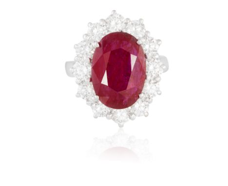 A RUBY AND DIAMOND CLUSTER RINGThe oval-shaped ruby weighing approximately 4.00cts, within a surround of round brilliant-cut 