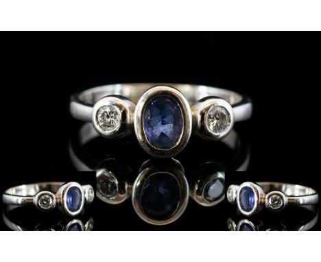 18ct White Gold Tanzanite And Diamond Ring Central tanzanite between two round modern brilliant cut diamond, ring size O, ful