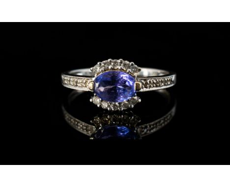 18ct White Gold Tanzanite And Diamond Dress Ring Central oval tanzanite surrounded by round cut diamonds, ring size N, fully 