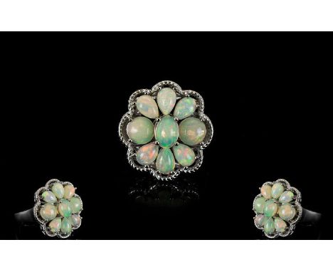 Opal Cluster Ring, comprising six pear cut and two round cut opal cabochons, closely set around an oval opal, totalling 3cts,