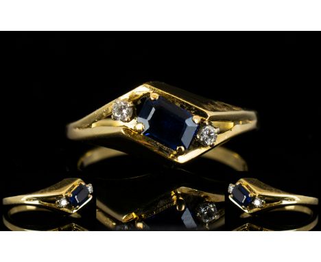 14ct Gold Sapphire And Diamond Dress Ring Set with central step cut sapphire between two round cut diamonds on a twist, fully