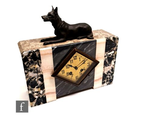 A French Art Deco polished marble cased mantel clock of rectangular form, with a spelter finial in the form of a recumbent Ge