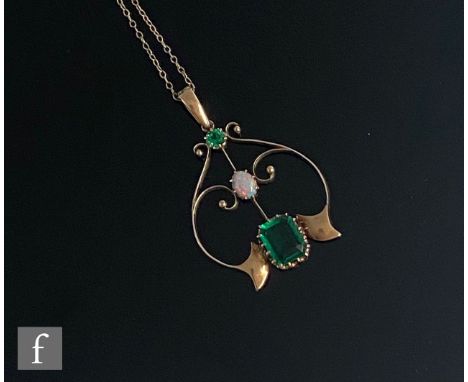 An early 20th Century 9ct open work pendant set with two green stones and central opal, suspended from a fine trace chain, to