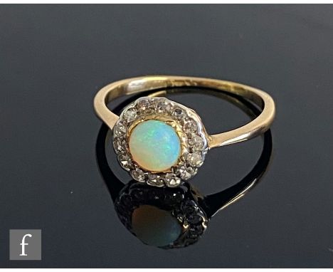 An early 20th Century 18ct opal and diamond cluster ring, central opal collar set within a border of fourteen diamonds, weigh