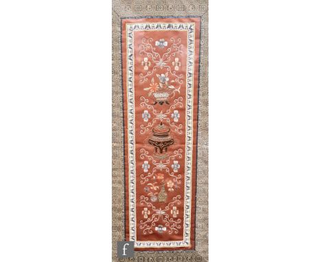 An early 20th Century Chinese embroidered silk panel, the deep russet ground embroidered with depictions of vases and censers