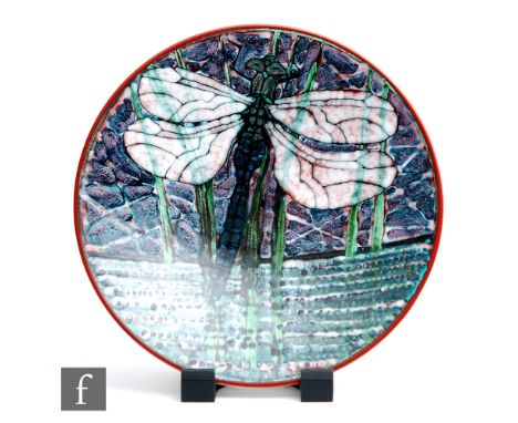 A later 20th Century Poole Studio charger decorated by Tony Morris with a large dragonfly amidst grasses, against a purple an