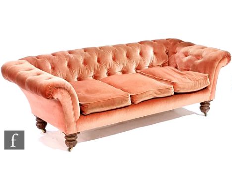 A Victorian Chesterfield type three seat sofa or settee, upholstered in pink button down dralon over acanthus carved feet wit