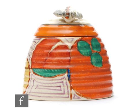 A large Clarice Cliff Beehive honey pot circa 1931, hand painted in the Melon pattern with a band of abstract fruit with oran