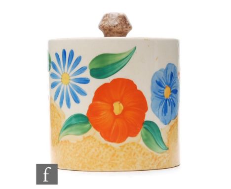 A Clarice Cliff drum shaped preserve pot and cover circa 1932, hand painted in the Canterbury Bells pattern with a band of st