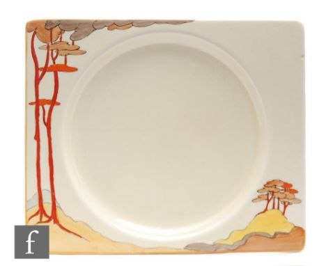 A Clarice Cliff Biarritz dinner plate circa 1934, hand painted in the Coral Firs pattern with a stylised tree lined landscape