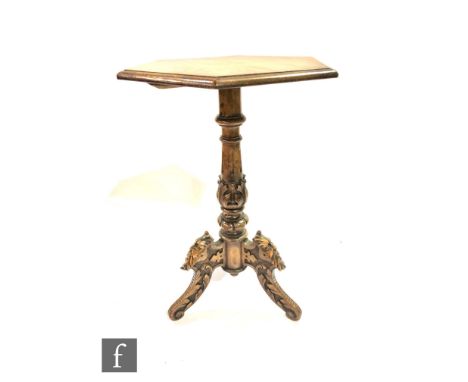 A Victorian octagonal walnut tripod table on turned carved pedestal and mask and leaf carved scroll legs, diameter 52cm. 