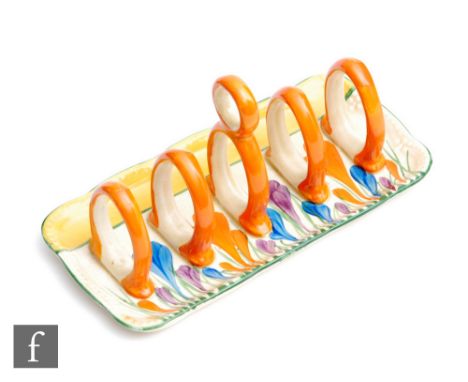 A Clarice Cliff toast rack or rounded rectangular form with five arched divisions circa 1930, hand painted in the Crocus patt