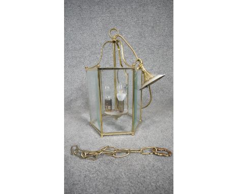 A Victorian style brass and glass porch lantern. The lamp of a hexagonal form with six bevelled glass panels. H.63 W.25 D.25 