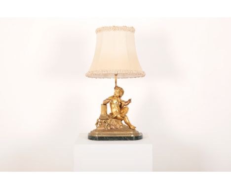 AN ORMOLU PUTTI LAMP19th century, converted to a lamp with silk ruffled shade, the cherub seated leaning against a classical 