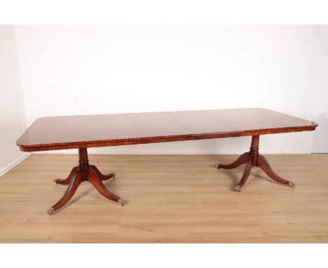 A MAHOGANY TWIN PEDESTAL DINING TABLE IN GEORGE III STYLEincluding three leaves, terminating on brass lion paw feet with cast